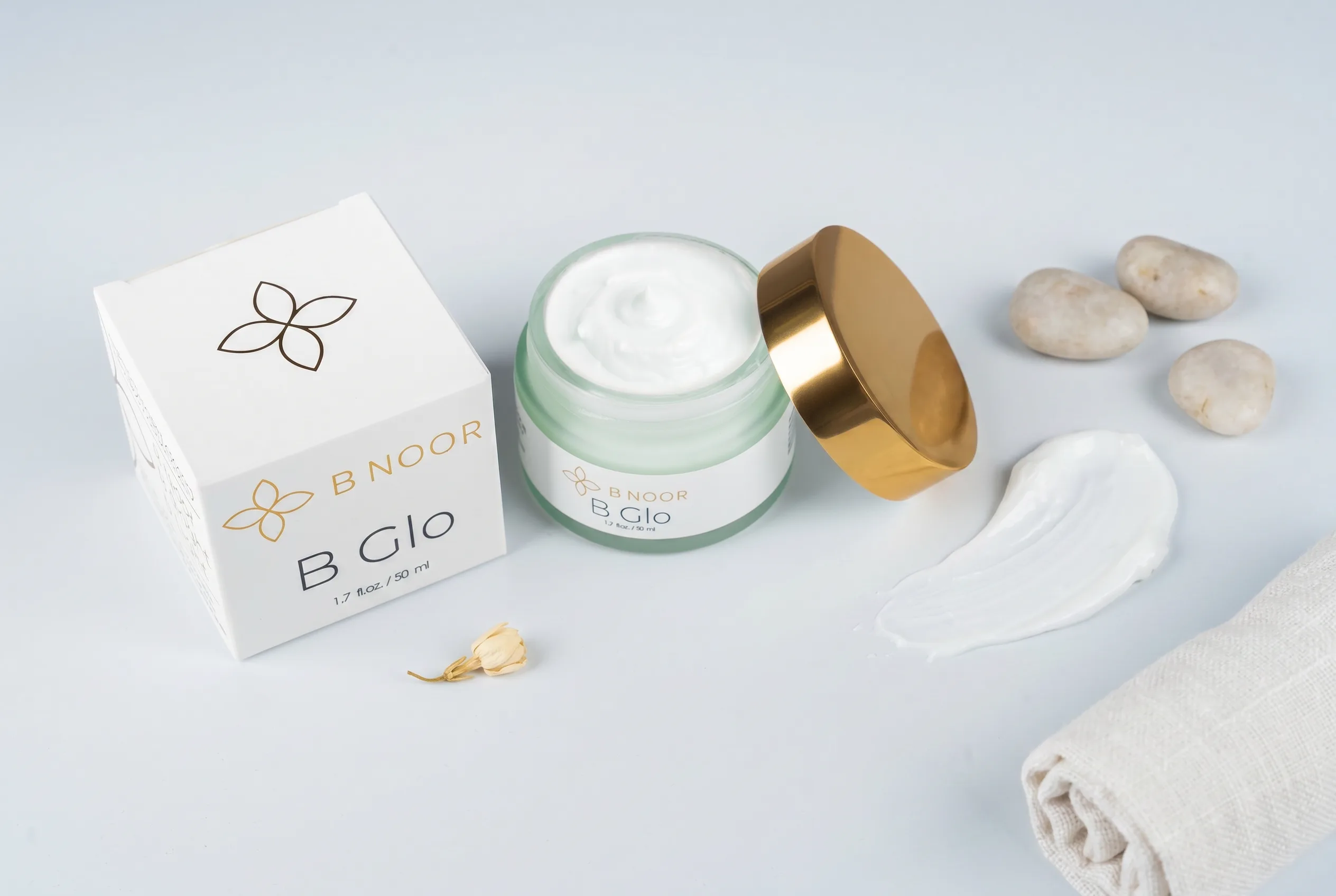 B NOOR B Glo hydrating cream flat lay with complementary skincare items — top-down shot